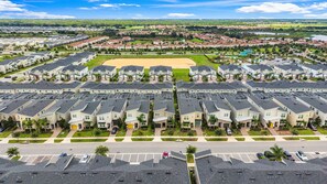 A residential area with multiple apartment buildings, a sports field, and a parking lot. - 5BR - Gorgeous Pool Home - Close To Disney, Golf and Water Park (Davenport)