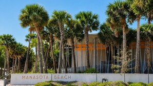 A building with a sign that reads 'Manasota Beach.' - The Flamingo at Palm Manor – 2BR Pool View (Englewood)