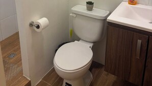 Uma casa de banho pequena com sanita, lavatório e armário.