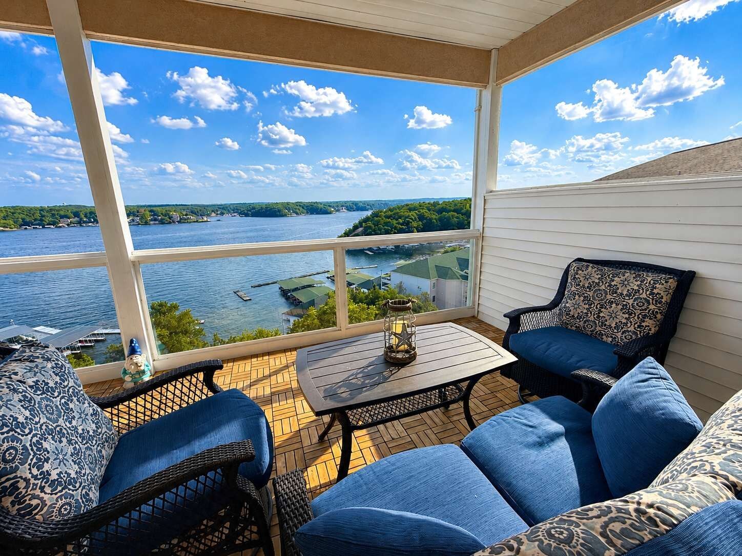 A covered outdoor seating area with a view of a lake and docked boats.