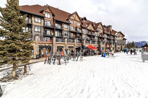Een meerlaags hotel met een ski verhuur en een skilift gebied.