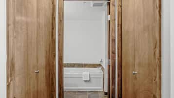 A bathroom with a bathtub, a towel, and a shower head.
