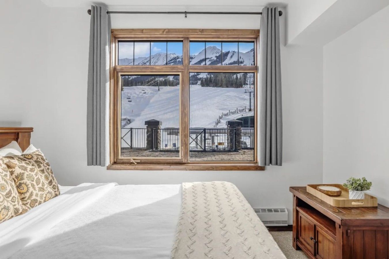 Une chambre avec une grande fenêtre donnant sur un paysage montagneux enneigé.
