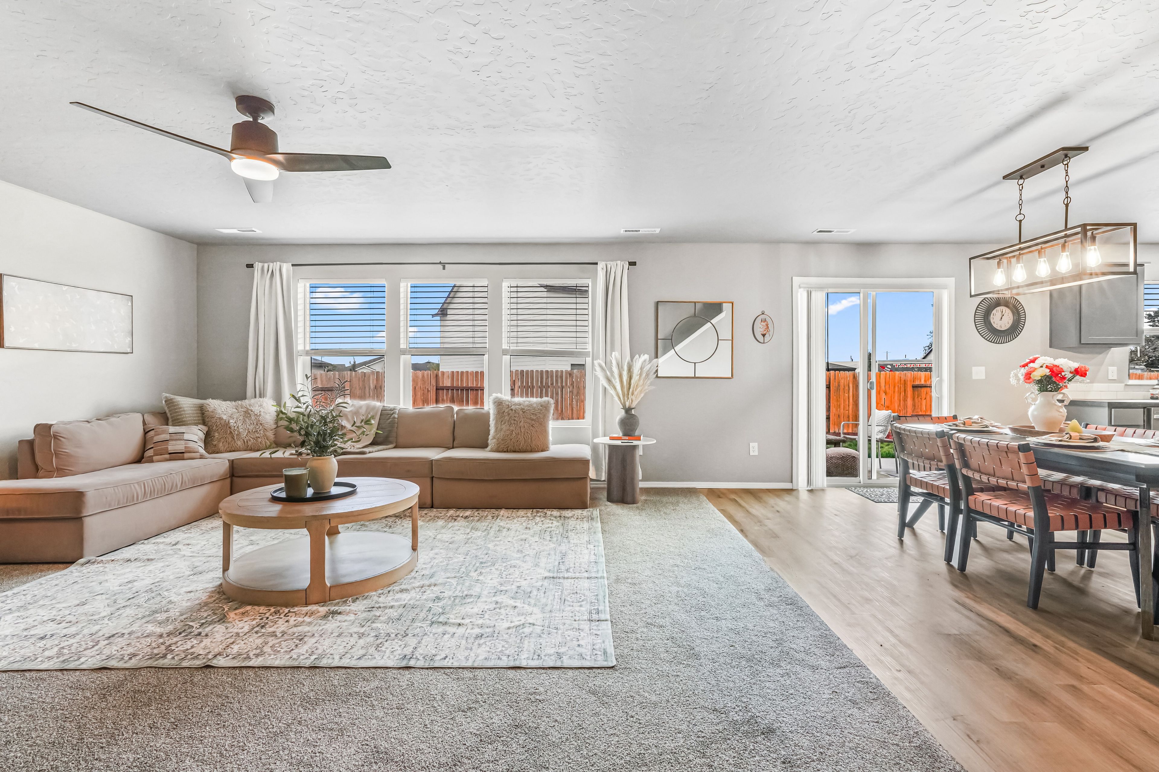 A spacious living room with a sofa, coffee table, and a dining area with chairs and a table.