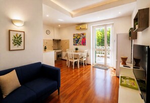 Eine moderne Wohnung mit Wohnzimmer, Essbereich, Küche und einem Balkon mit Aussicht.
