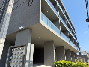A modern building with a flat facade, numbered 400, and a set of electrical panels at the base.