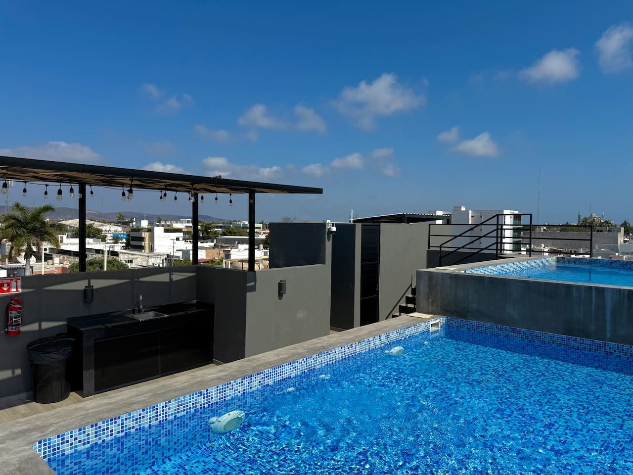 A rooftop swimming pool with a view of the cityscape.