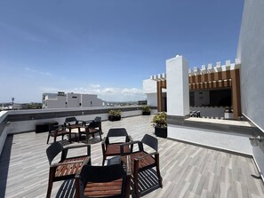 Eine Dachterrasse mit Sitzgelegenheiten und Blick auf die Stadt.