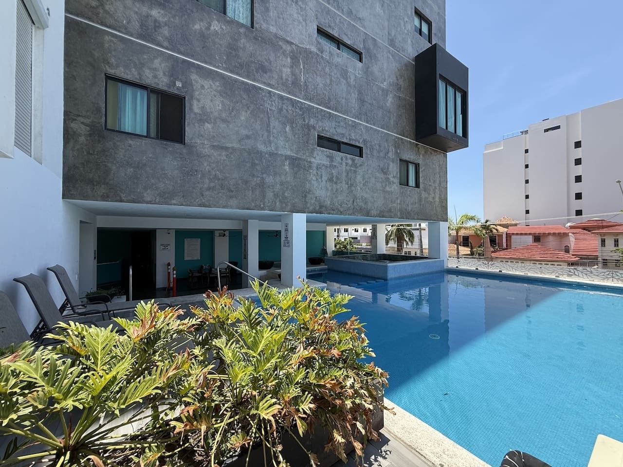 Um edifício moderno com piscina, área de estar externa e vista para os arredores.