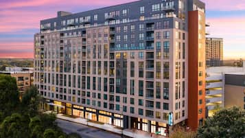 A multi-story hotel with a modern design, featuring a prominent entrance and a large parking area.