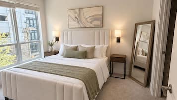Een slaapkamer met een groot bed, een plafondventilator, een raam en een spiegel.