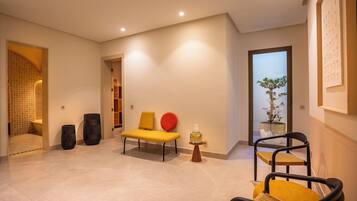 A modern living room with a sofa, chairs, a potted plant, and a decorative vase.