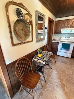 A kitchen with wooden cabinets, a white stove, and a dining table with chairs.
