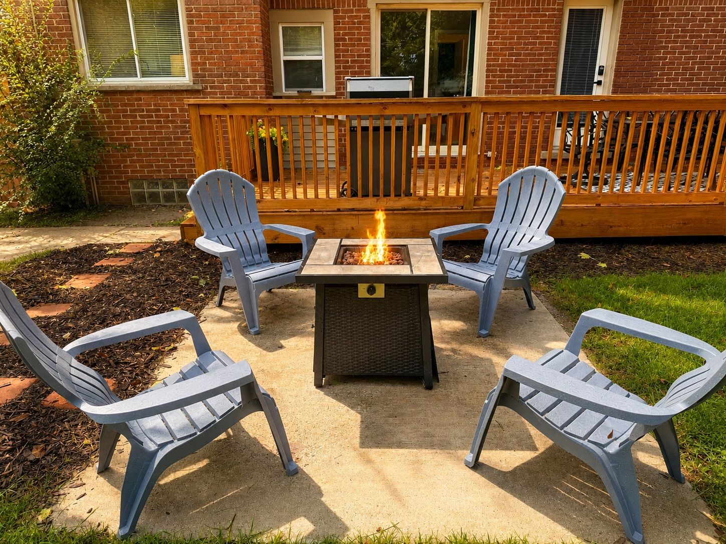 Een terras met een vuurkuil en vier Adirondack-stoelen.
