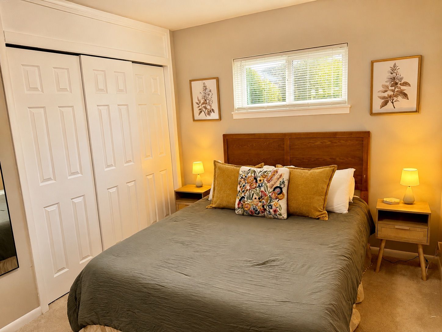 A bedroom with a bed, two bedside tables, a window, and a door.