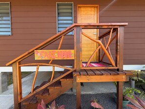 A wooden staircase with a sign reading 'FAREHANI' leading to a wooden door.