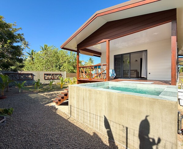 A modern house with a swimming pool, a covered patio, and a garden.