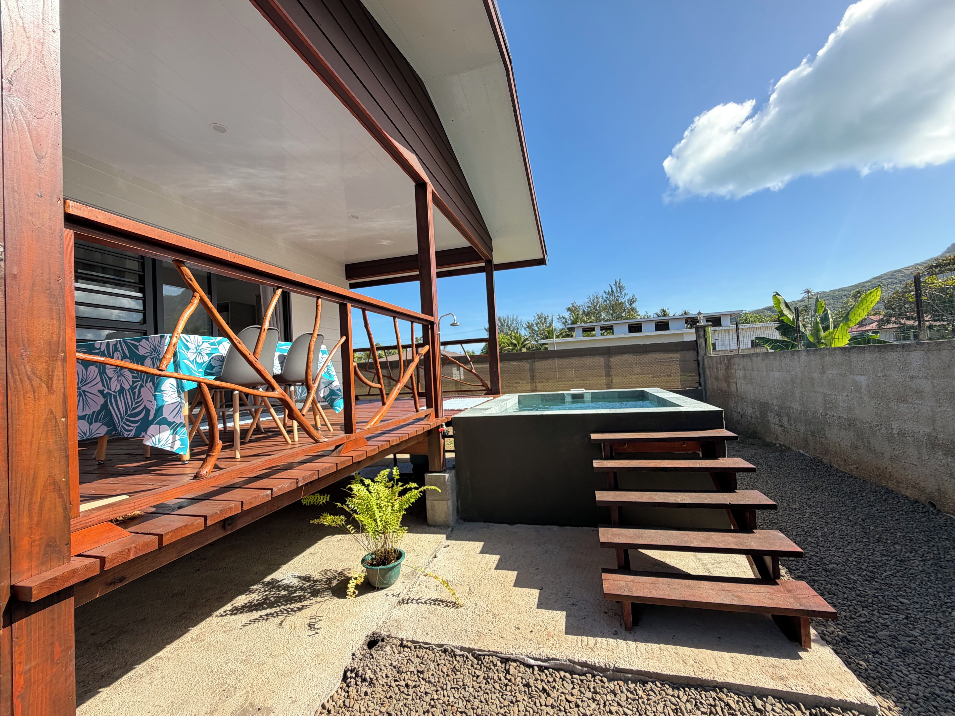 Une terrasse extérieure moderne avec une piscine, des meubles en bois et une vue sur les environs.