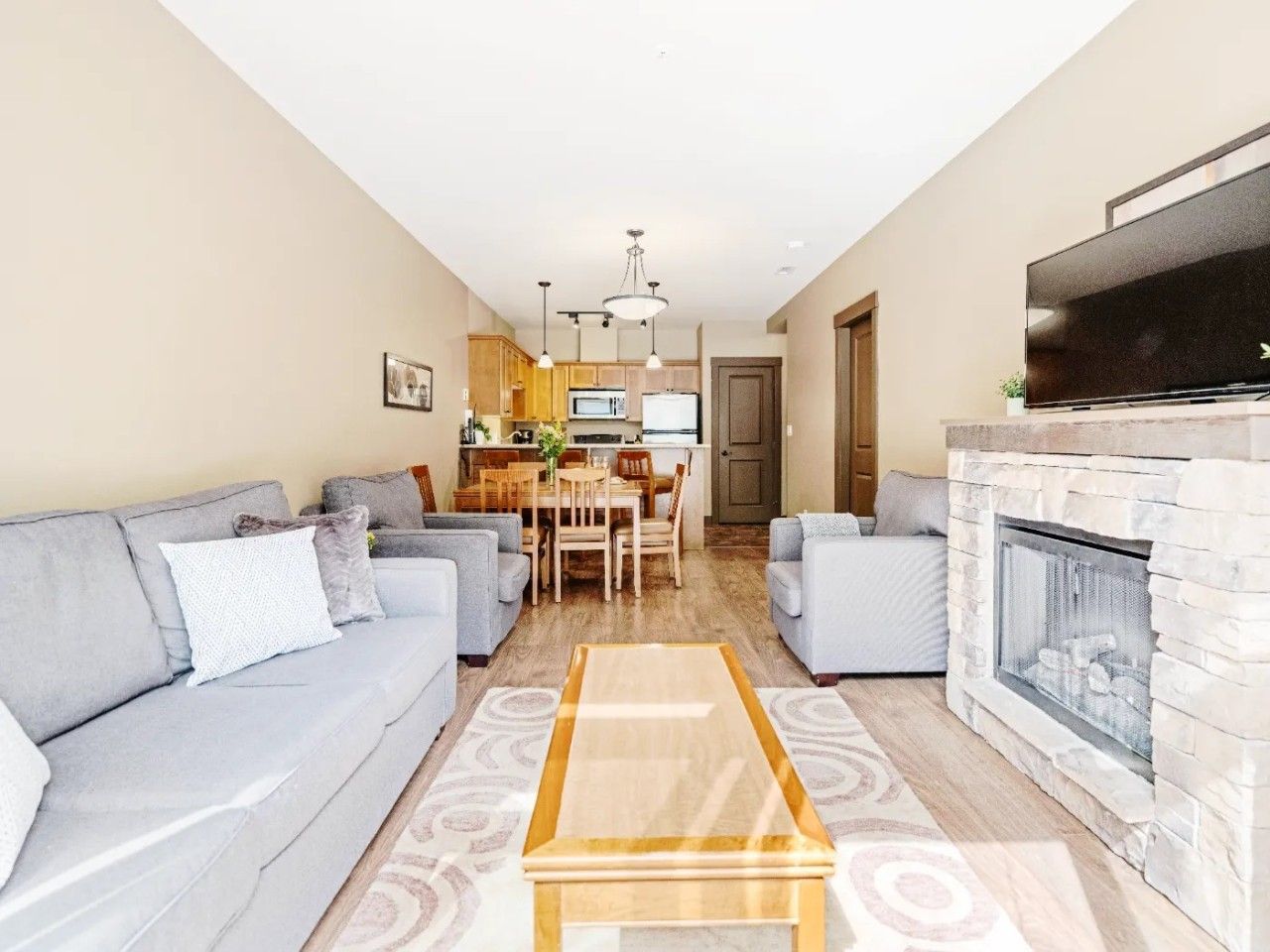 A living room with a sofa, a coffee table, and a fireplace.