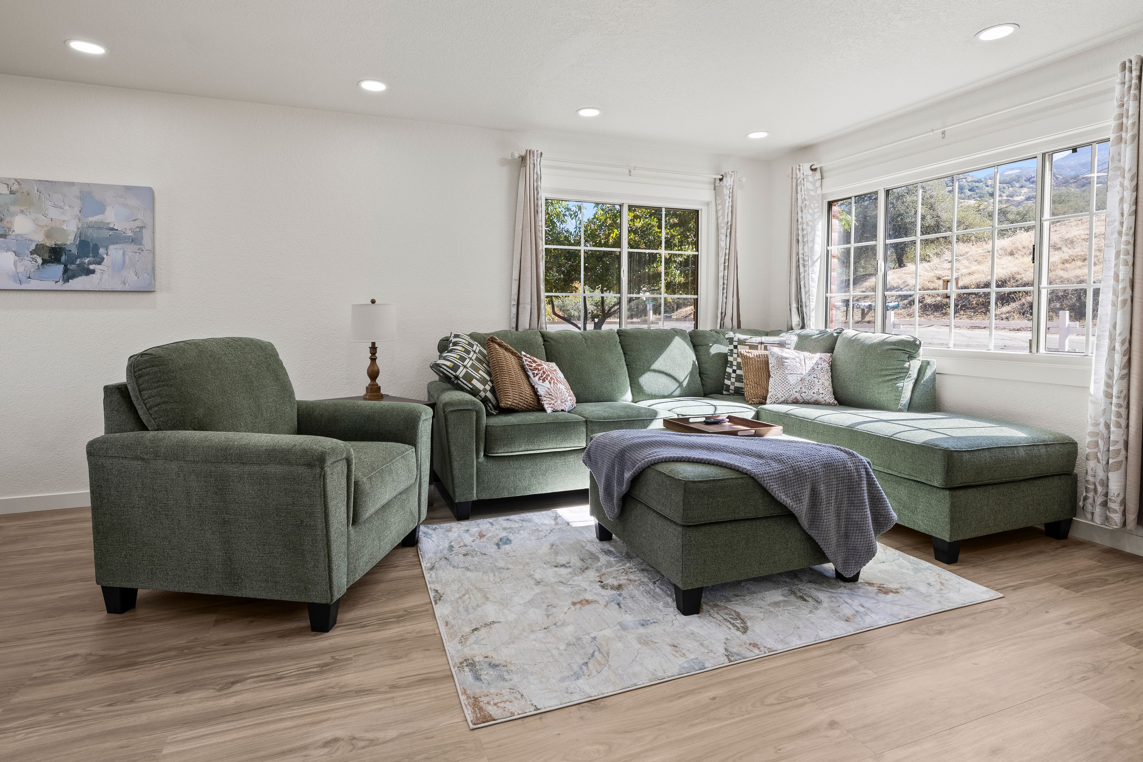 A living room with a sectional sofa, a single armchair, and a coffee table.
