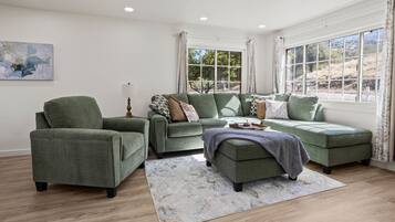A living room with a sectional sofa, a single armchair, and a coffee table.