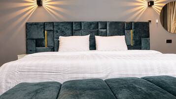 Ein modernes Schlafzimmer mit einem großen Bett, einer gesteppten Kopfteil und Wandleuchten.