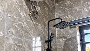A bathroom with a shower, a water heater, and a window. - Xpression Apartment  (Akure)