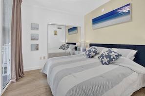 Un dormitorio con una cama grande, un espejo y obras de arte en las paredes.