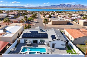Ein Wohngebiet mit Schwimmbad, Solaranlage und Blick auf ein Gebirge.