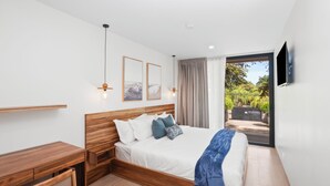 Een moderne slaapkamer met een houten bed, een bureau en een groot raam.