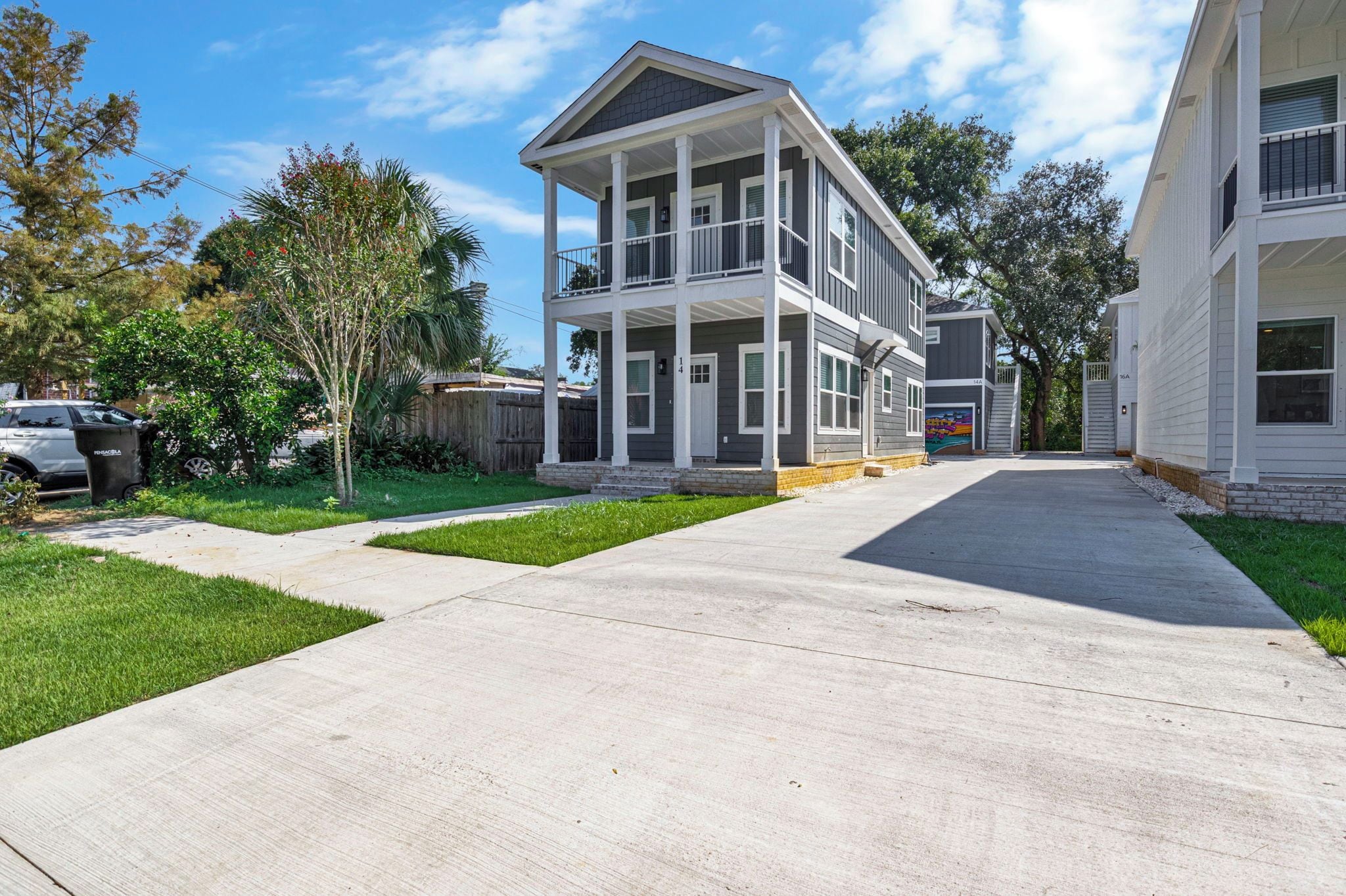 A two-story residential building with a covered porch and a garage.