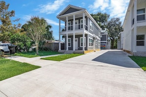 Ein zweistöckiges Wohnhaus mit überdachter Veranda und Garage.
