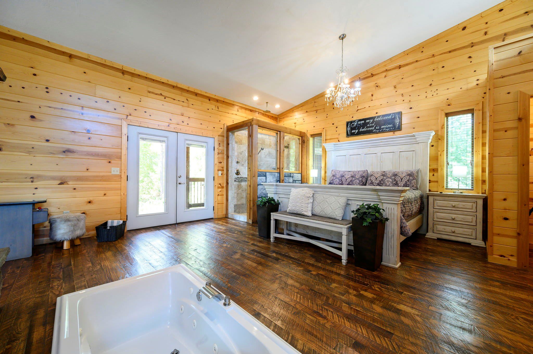 Ein Holzblockhaus-Interieur mit einer großen Badewanne, einer Sitzbank und einem Kamin.