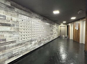 A hallway with lockers, a wooden wall, and a door at the end. - FREE PARKING!! 2 Bedroom Vacation Rental - Corner Unit with Great Views! (Honolulu)