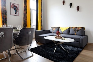 A living room with a grey sofa, a round coffee table, and two armchairs.