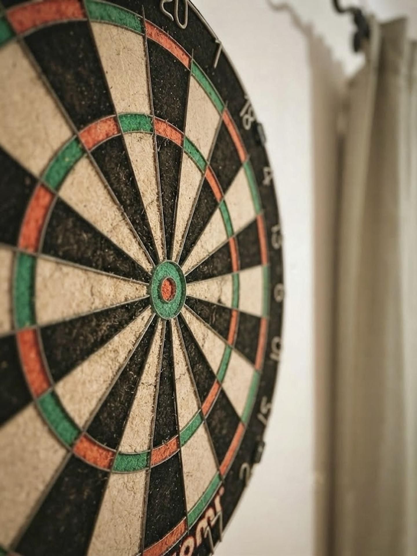 Een dartbord met nummers en gekleurde ringen.