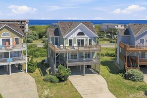 Ein Strandgrundstück mit mehreren zweistöckigen Gebäuden, jedes mit einem Balkon und Blick auf den Ozean.
