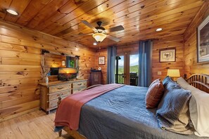 A wooden cabin bedroom with a bed, dresser, and a ceiling fan. - Always on My Mind - Mountain View | Pet Friendly | Hot Tub | Firepit (Mineral Bluff)