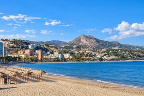 A coastal cityscape with a beach, buildings, and a mountain. - Guestready - Malaga Art and Comfort Apartments (Málaga)