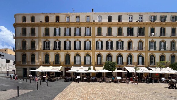 A historic building with multiple balconies and a paved courtyard with outdoor seating. - Guestready - Malaga Art and Comfort Apartments (Málaga)