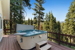 A hot tub on a wooden deck with a view of tall trees. - Kimberly Luxury Cabin - Hot Tub, Walk to Town (Tahoe City)