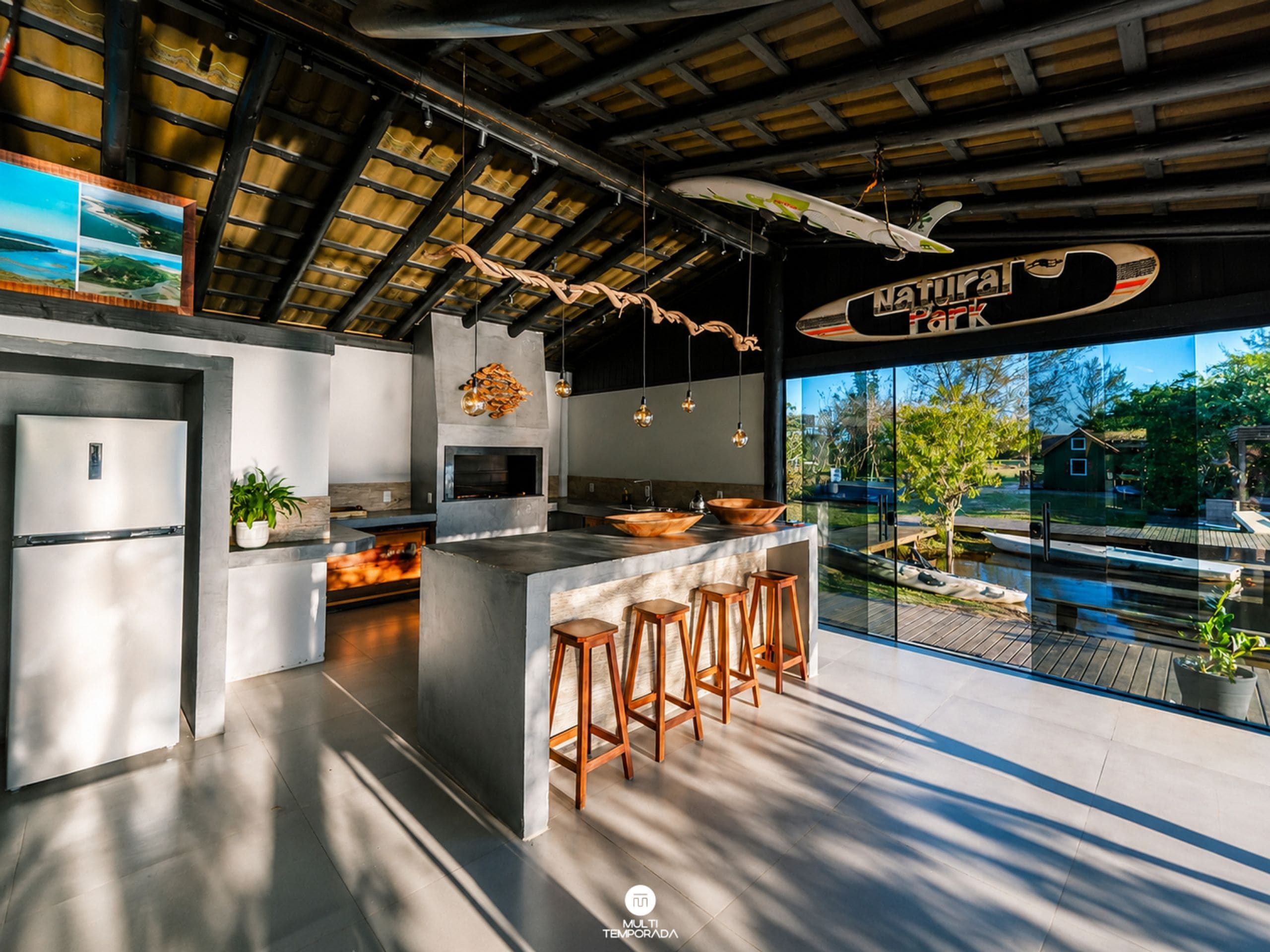 Una cocina moderna con una isla grande, taburetes de bar y vistas a un cuerpo de agua.