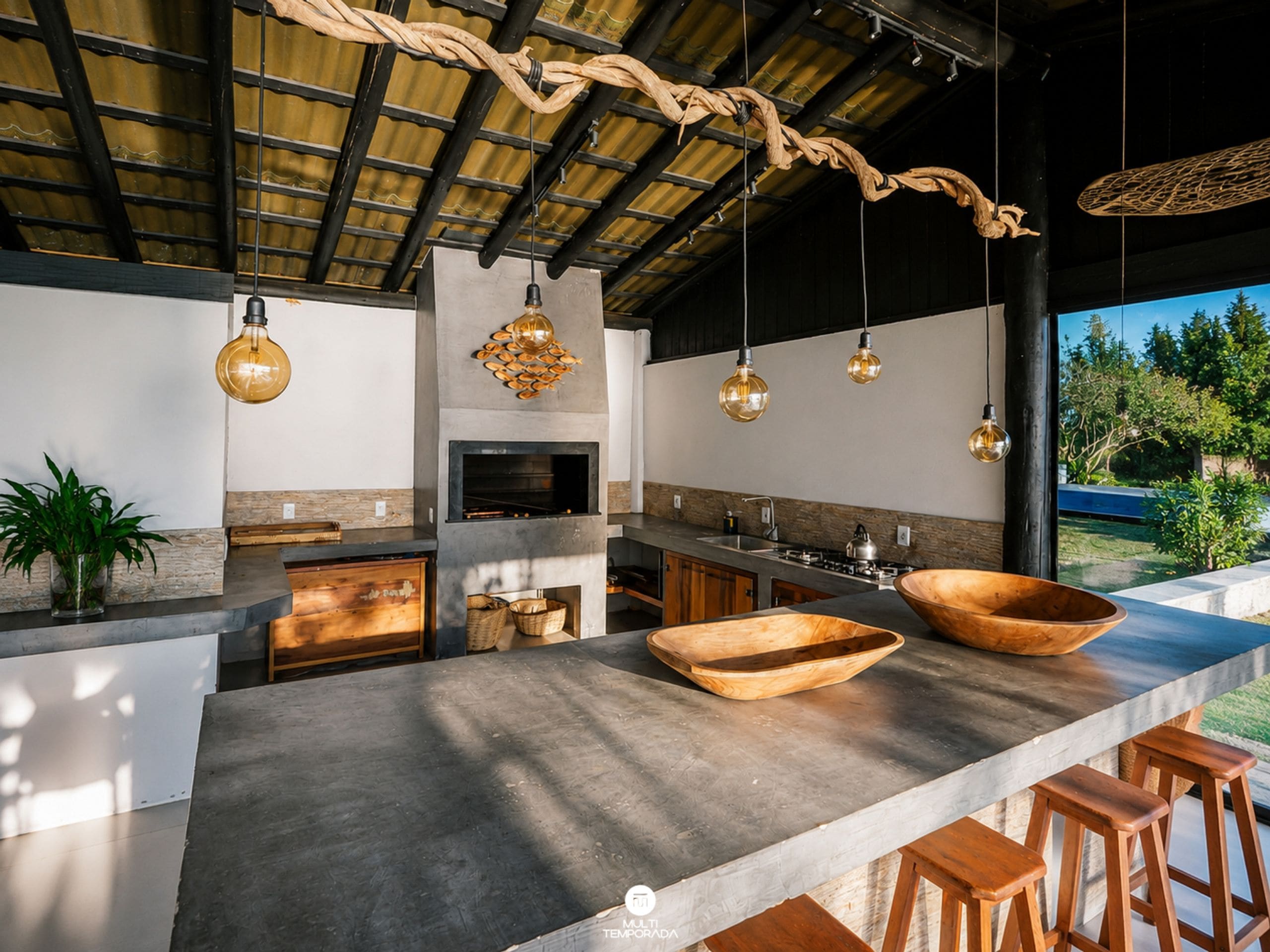 Una cocina moderna con una isla grande, lámparas colgantes y vistas al exterior.