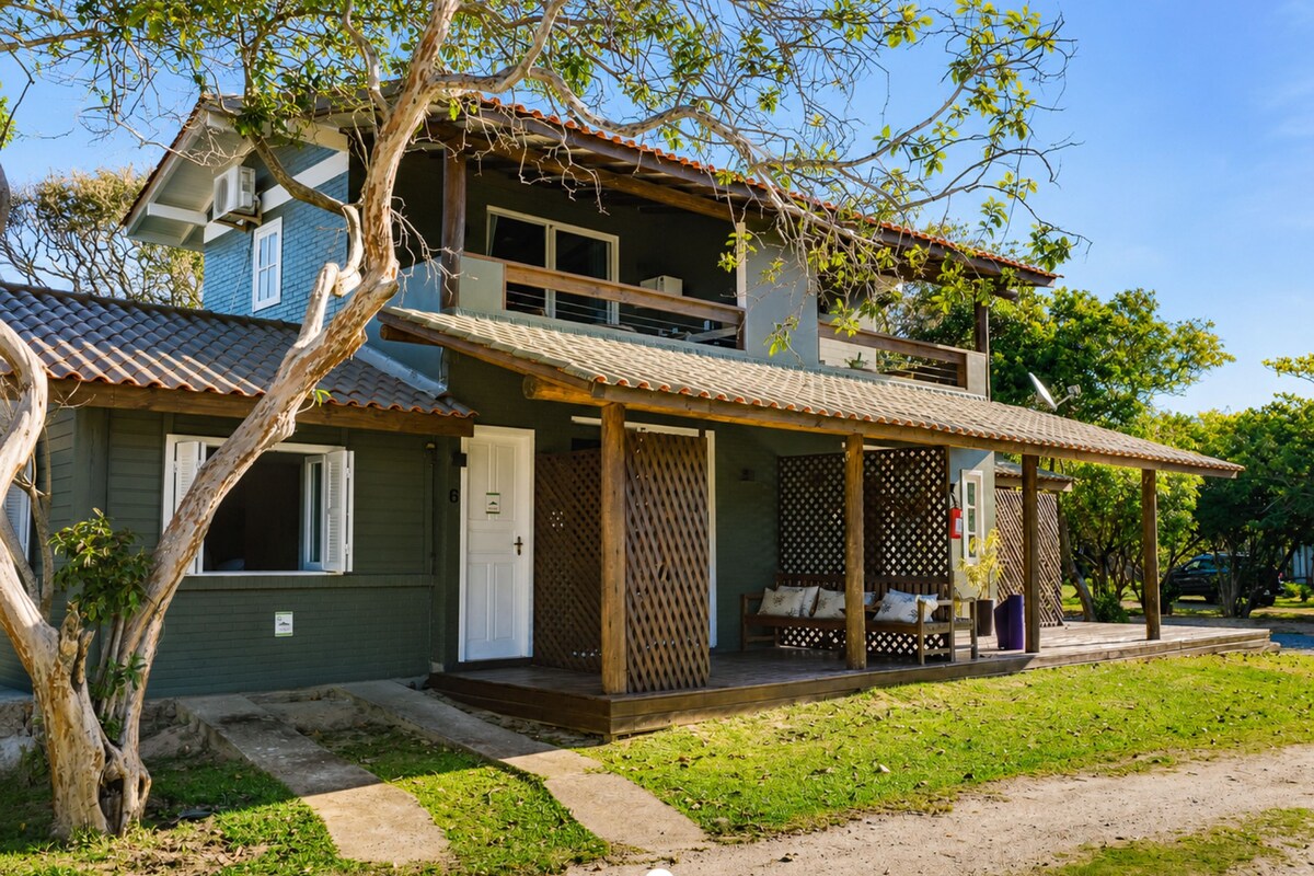 A two-story house with a covered porch and a small garden area.