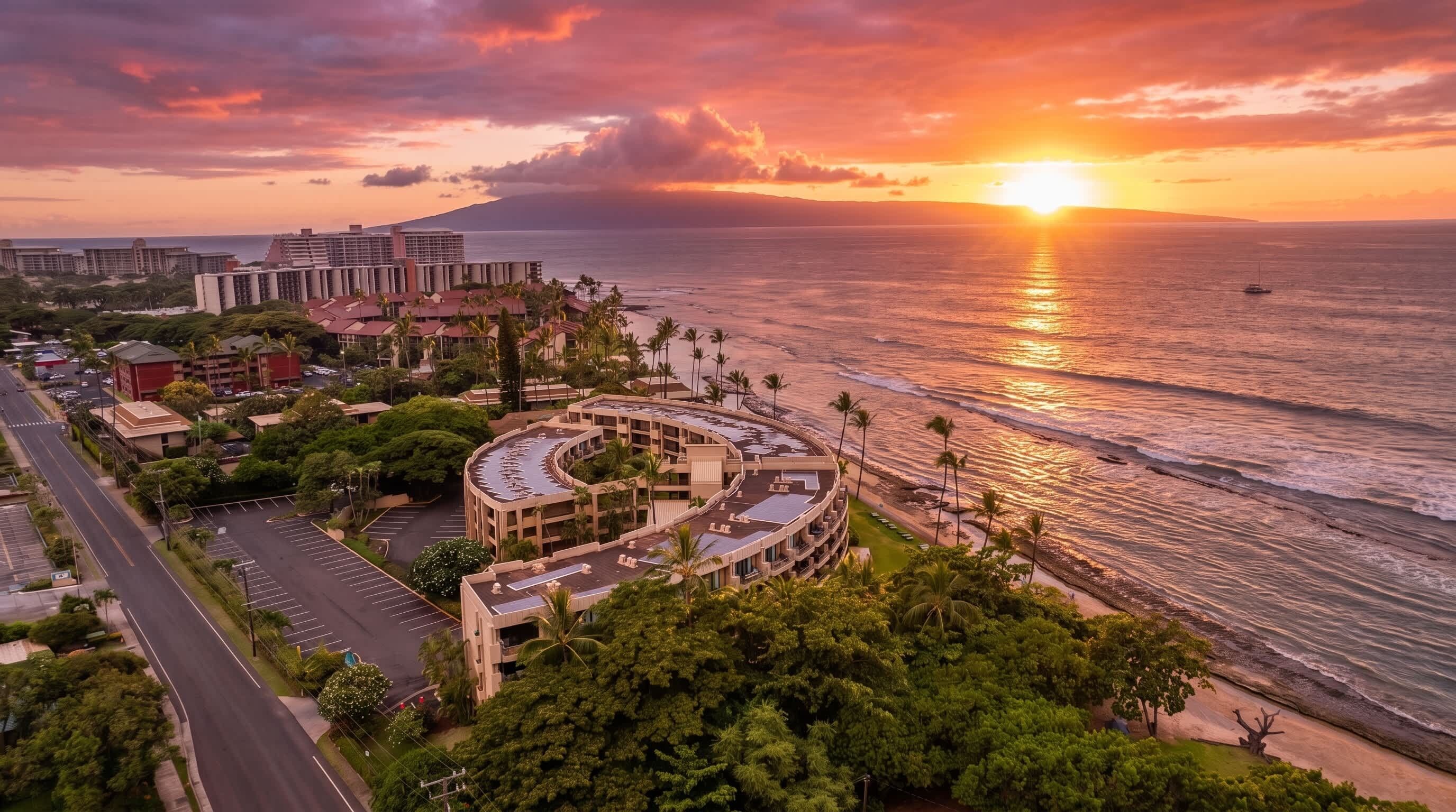 A coastal hotel with a curved building, beachfront parking, and ocean views.