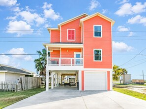 A two-story house with a balcony, a garage, and a covered patio area. - Jamaica Beach | Bayfront | Hot Tub | Kayaks (Jamaica Beach)