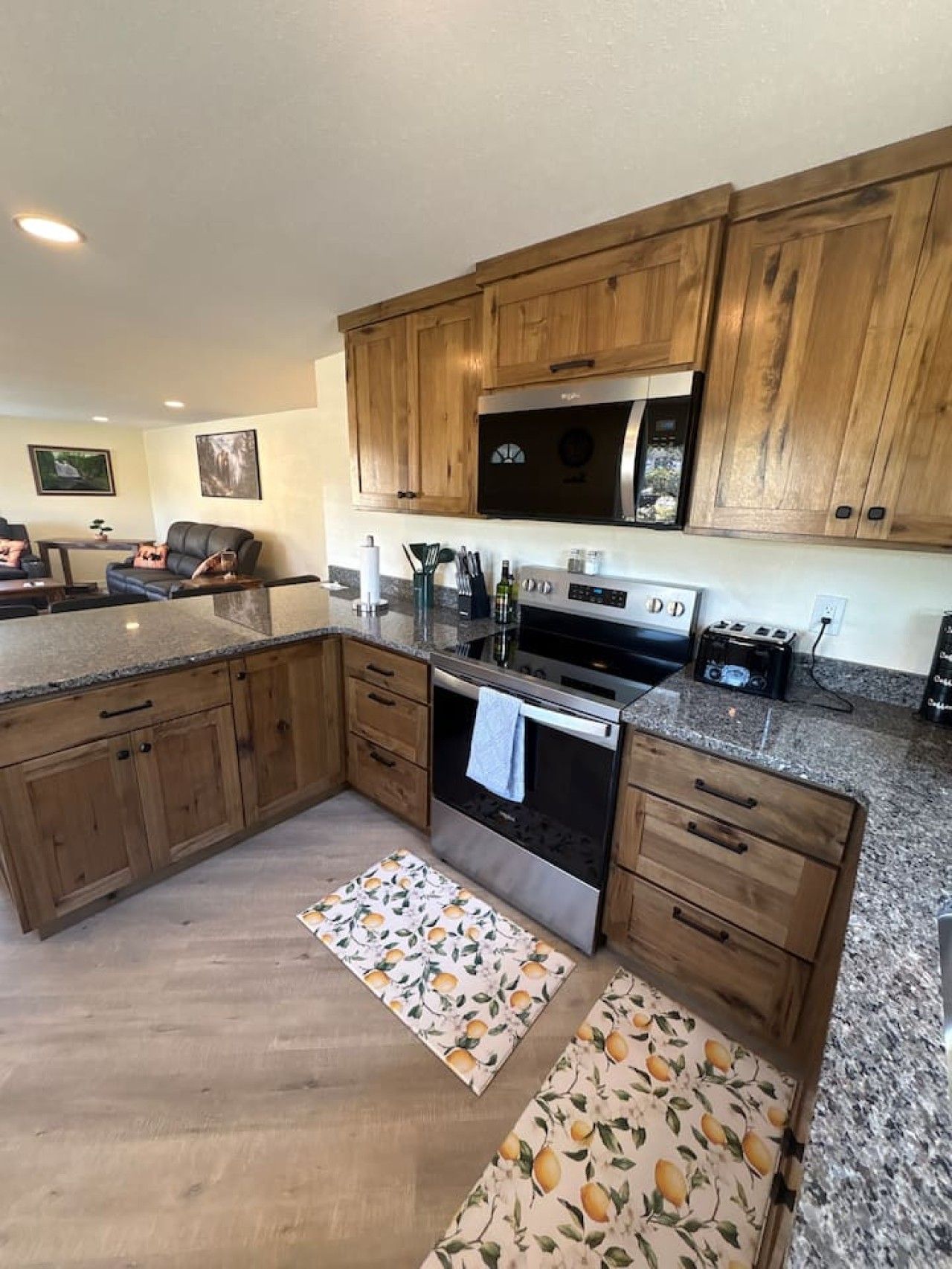 A kitchen with wooden cabinets, a stainless steel oven, and a granite countertop.