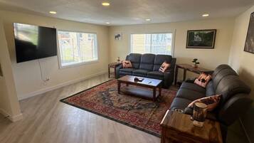 A living room with a sofa, coffee table, and a flat-screen TV.