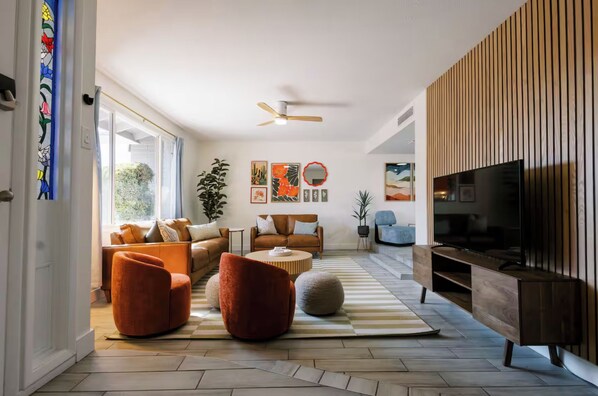 A modern living room with a sofa, armchairs, a coffee table, and a TV. - Backyard Oasis, Pool, Spa, Game Room, BBQ (Scottsdale)