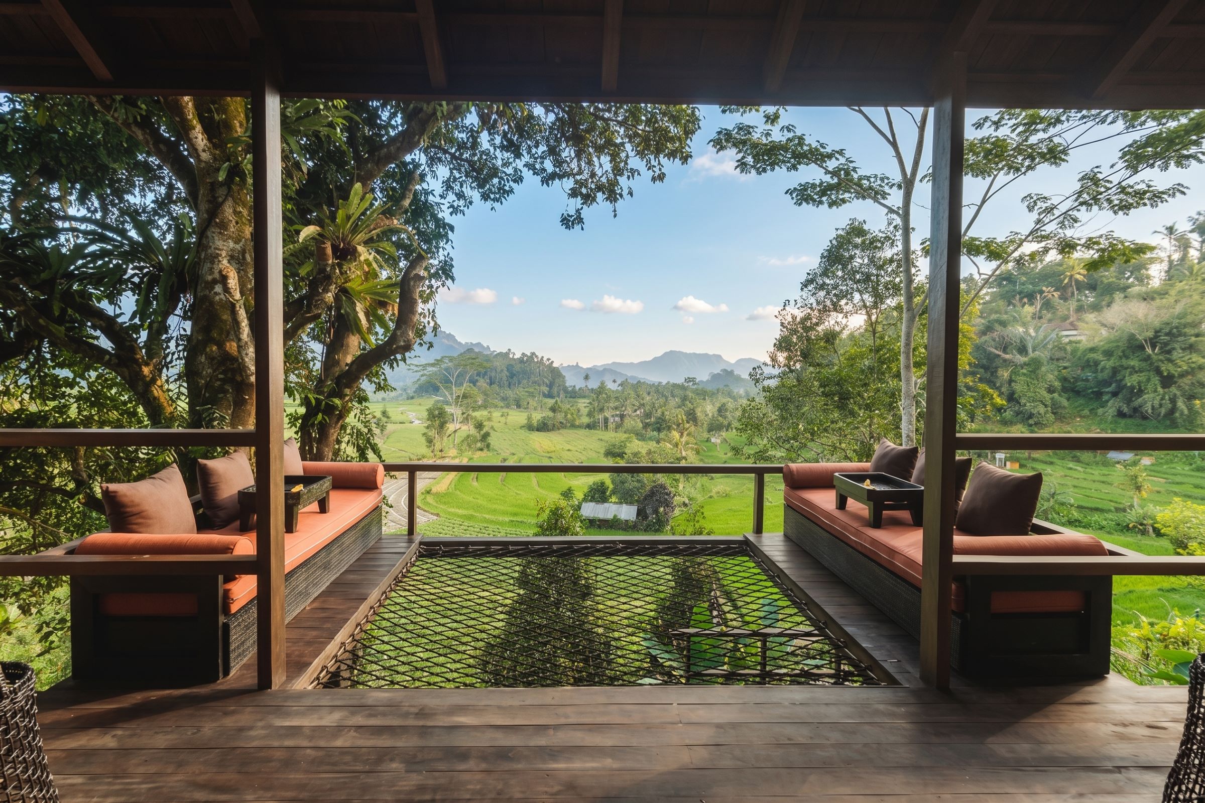A covered outdoor seating area with a view of a green landscape.